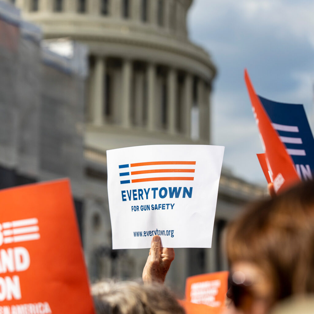 An Everytown sign is raised in a crowd in front of the Capitol