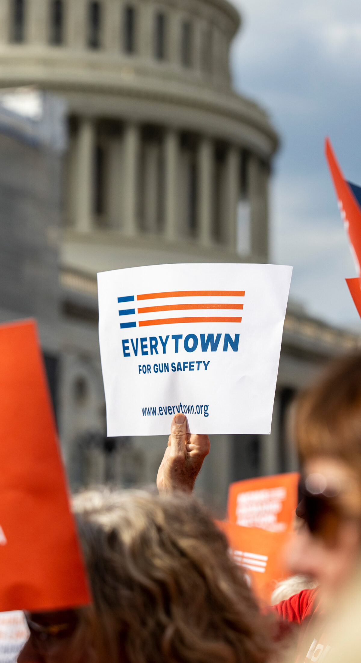 An Everytown sign is raised in a crowd in front of the Capitol