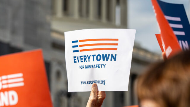 An Everytown sign is raised in a crowd in front of the Capitol