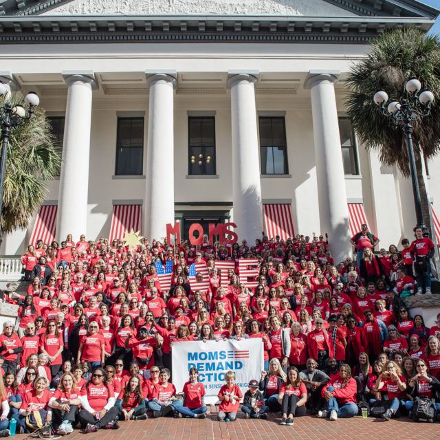 A large group of Moms Demand Action volunteers stand in front of the capitol at an Advocacy Day