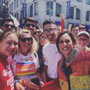 Kamala Harris poses for a photo with a group wearing Disarm Hate and Students Demand Action shirts