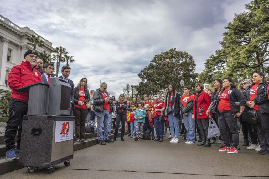A group of Moms Demand Action, Students Demand Action, and Everytown Survivor Network volunteers stand in a circle in front of the California Capitol building during an advocacy day.