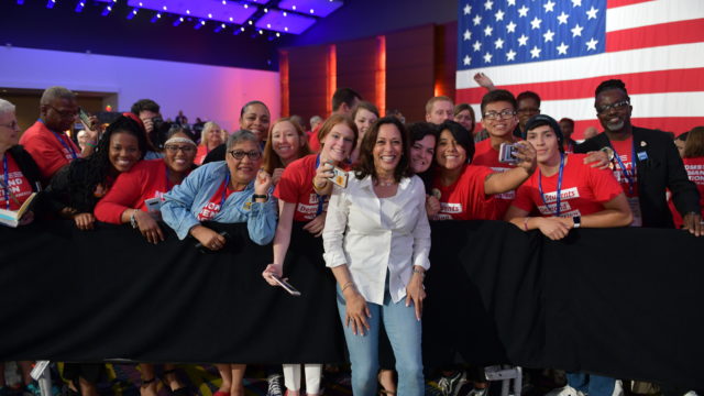 Kamala Harris smiles with a group of Moms Demand Action and Students Demand Action volunteers at the Presidential Gun Sense Forum