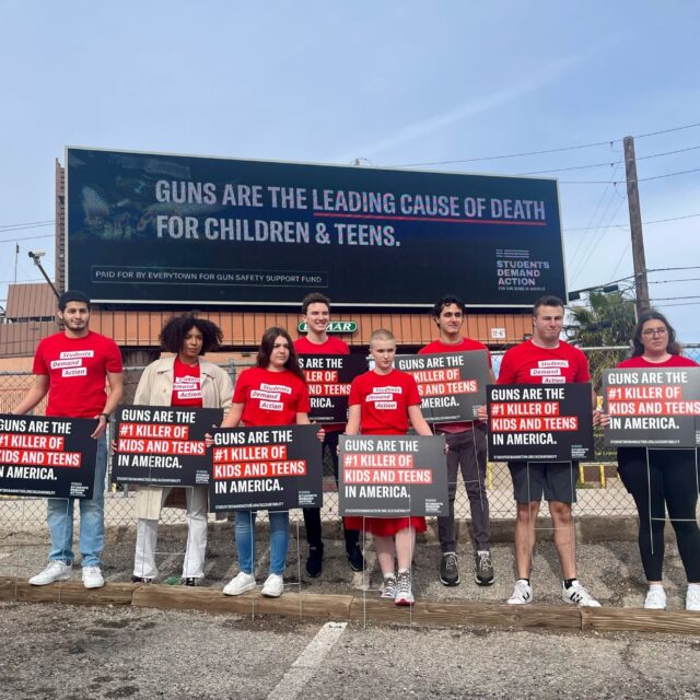 Students Demand Action volunteers holding up signs that say “Guns are the #1 killer of kids and teens in America.”