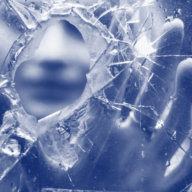 A blurred face and hand are visible in the background of the image, behind the foreground of splintered glass. In the center, there is a bullet hole through which the person's face is visible. The person appears to be reaching out toward the viewer. The image is meant to reflect how lives can be shattered by intimate partner homicide-suicide.